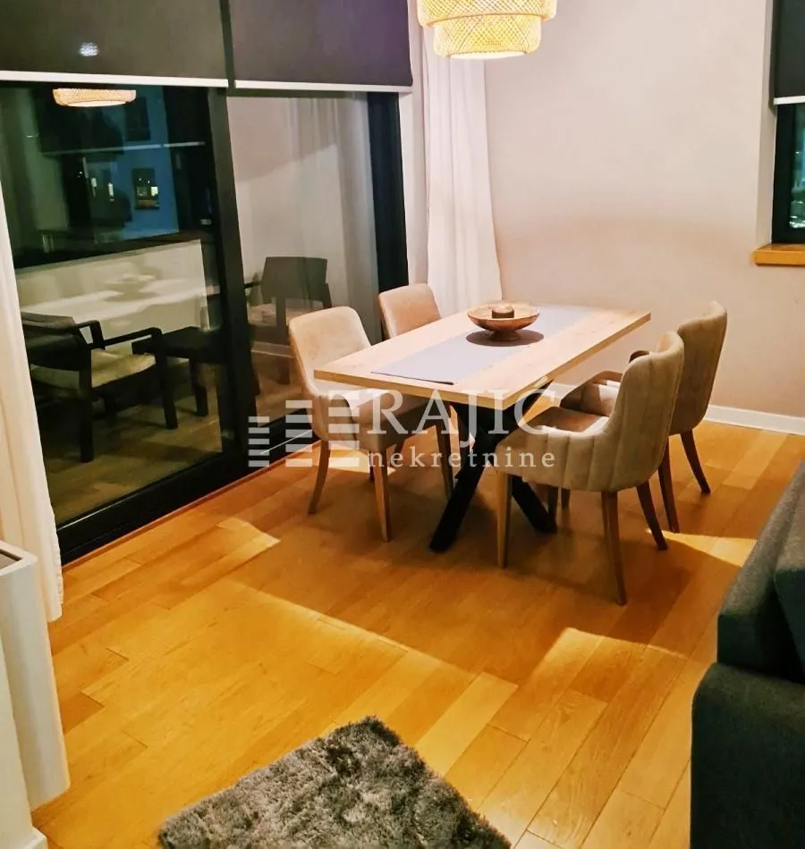 Modern dining area with a wooden table and chairs as part of the living room.