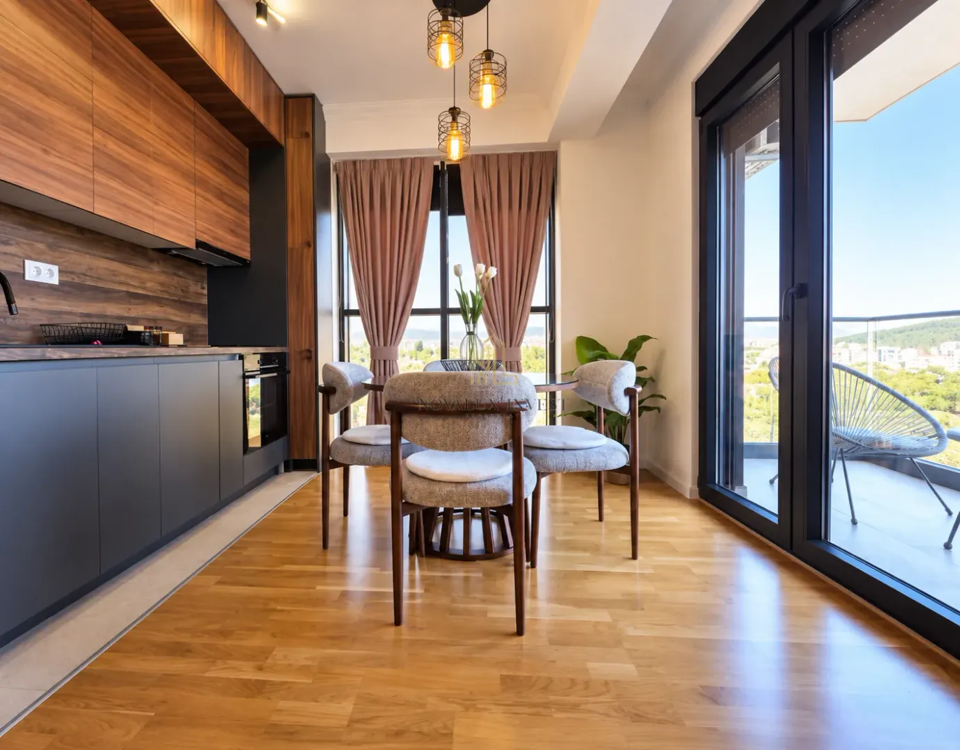 Modern kitchen with a dining area and large glass surfaces leading to the terrace.