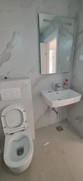 Moderno opremljeno kupatilo sa bijelim sanitarijama i mermernim pločicama. - image 9
