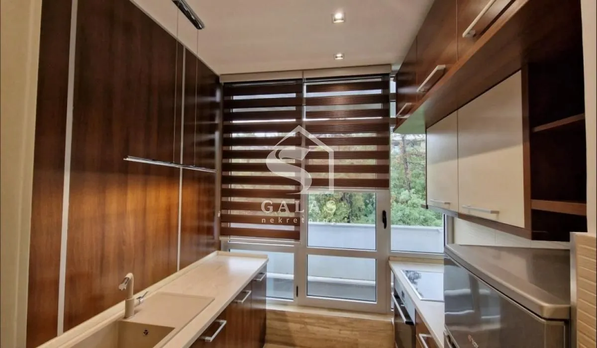 Modern kitchen with wooden cabinetry and built-in appliances.