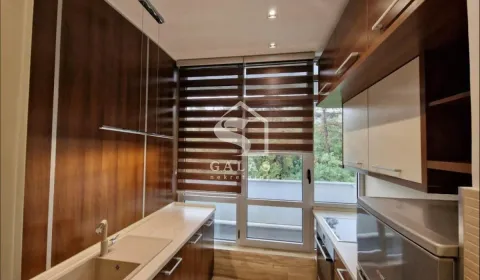 Modern kitchen with wooden cabinetry and built-in appliances. - image 4