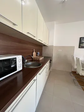 Modern kitchen with white cabinets and a dark countertop. - image 3