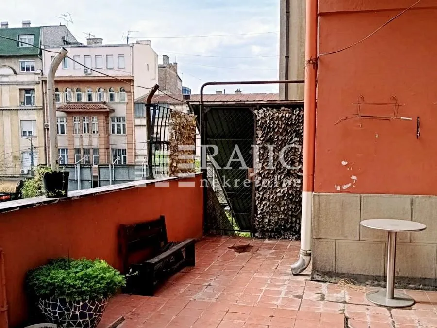 Spacious terrace with a view of surrounding buildings and the city street.
