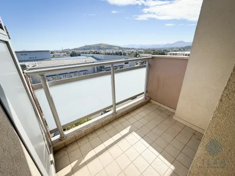 Small tiled balcony with glass railing and city view. - image 8