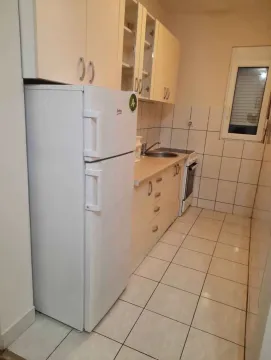 Small kitchen with light-colored cabinets and a white refrigerator. - image 3