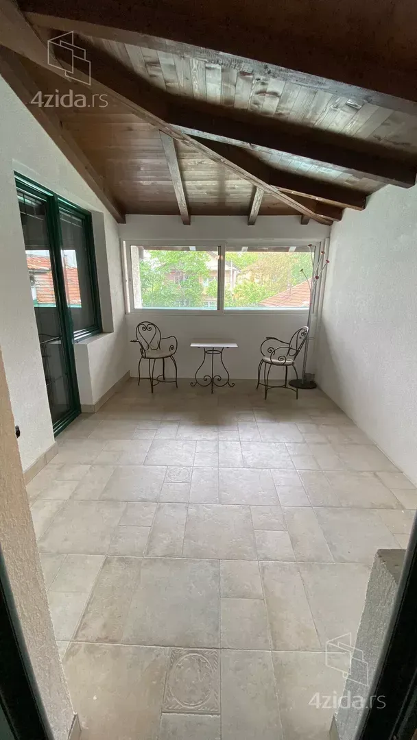 Covered terrace with a wooden roof and seating set.