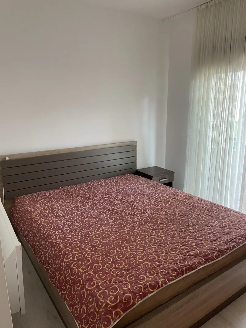 Furnished bedroom with a double bed and a nightstand.