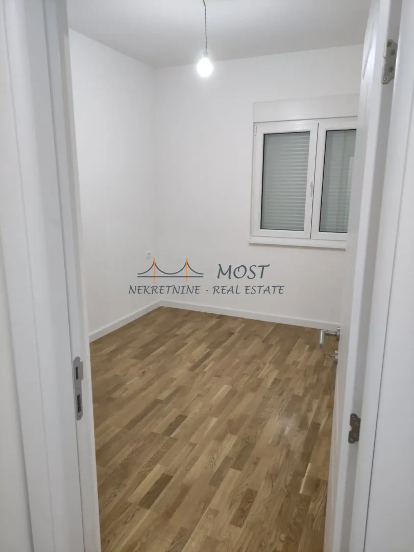 Empty room with parquet flooring and white walls.