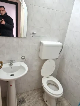 A small bathroom featuring a sink, mirror, and toilet. - image 11