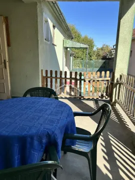 Natkrivena terasa sa stolom, stolicama i pogledom na dvorište. - image 14