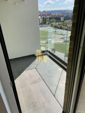 Manji popločani balkon sa staklenom ogradom i pogledom na naselje. - image 10
