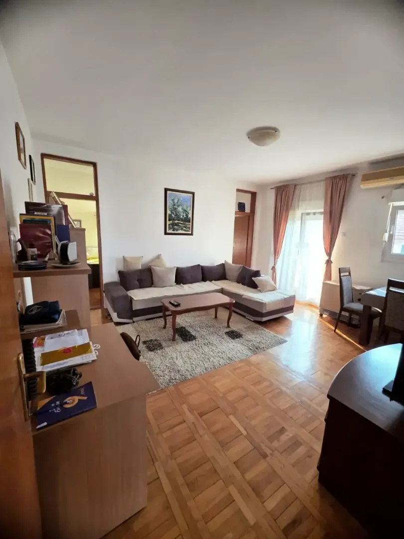 Prostrana dnevna soba sa garniturom i trpezarijskim dijelom.