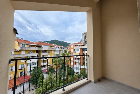 View from the balcony overlooking surrounding buildings and greenery. - image 13