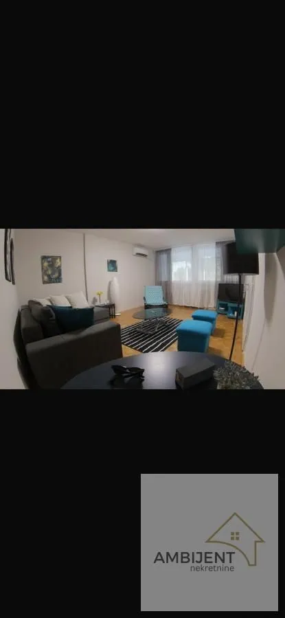 Udobna dnevna soba sa garniturom za sedenje i TV-om.