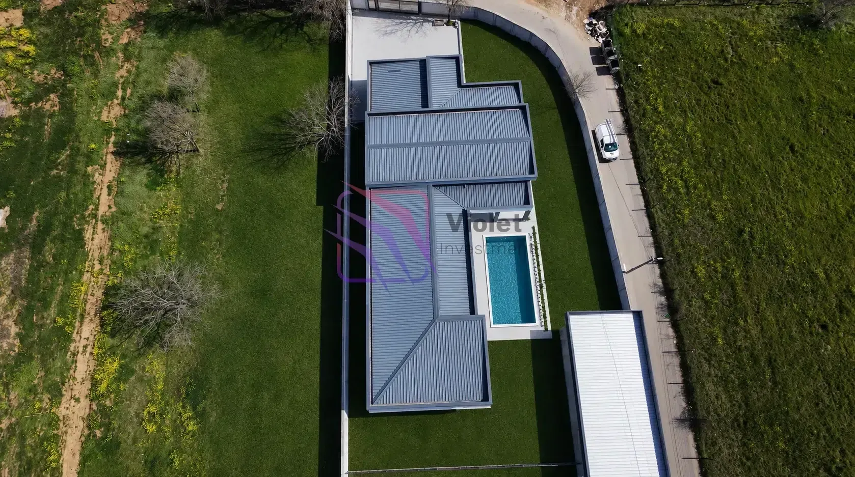 Aerial view of the house with a swimming pool and yard.