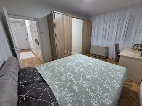 Nameštena spavaća soba sa bračnim krevetom, velikim ormanom i radnim stolom. - image 8