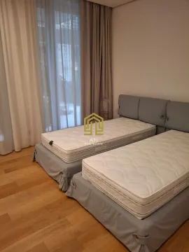 Spavaća soba sa dva odvojena kreveta i velikim prozorom sa zavjesama. - image 7