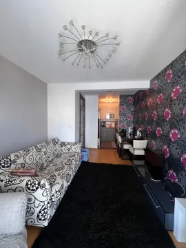 Dnevni boravak sa garniturom, crnim tepihom i dekorativnim tapetama na zidu. - image 4
