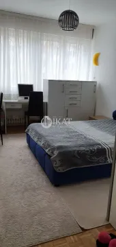 Furnished bedroom with a double bed, desk, and wardrobe. - image 8