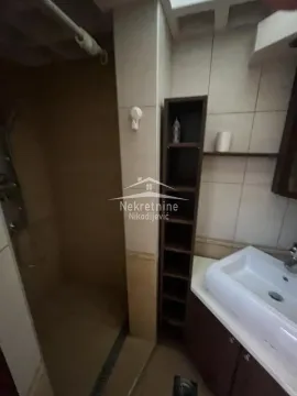 Small bathroom with a shower cabin and a washbasin. - image 10