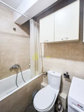 Manje kupatilo sa kadom, toaletom i zidnim ormarićem. - image 3