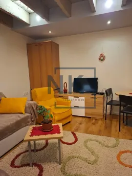 Living room with a sofa, armchair, and television. - image 2