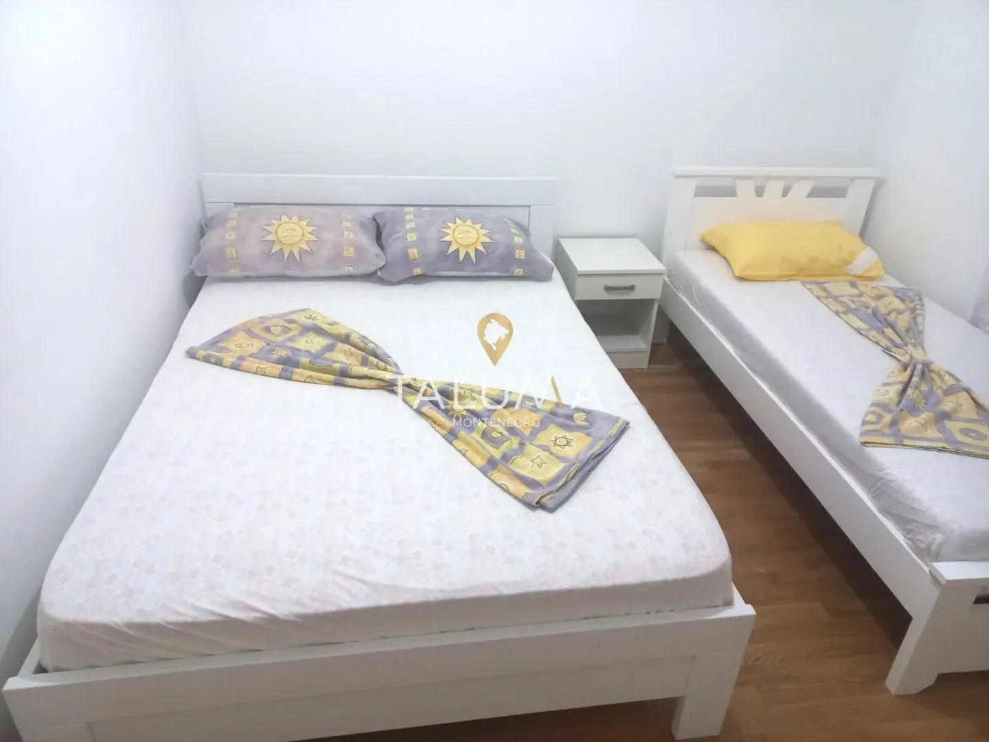Spavaća soba sa bračnim krevetom i jednim dodatnim krevetom.