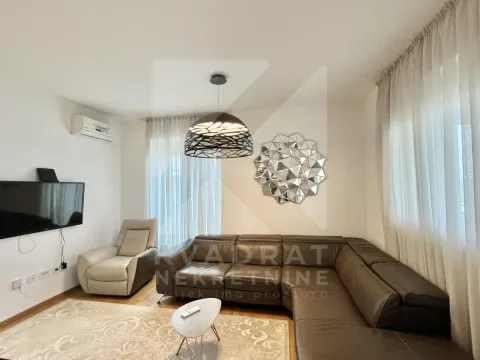 Living room with a sectional sofa, armchair, and wall-mounted TV. - image 14