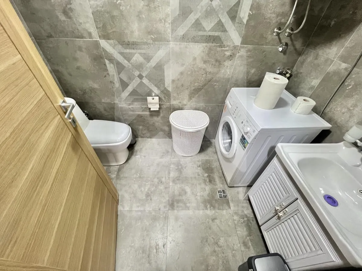 Kupatilo opremljeno sanitarijama, umivaonikom i veš mašinom.