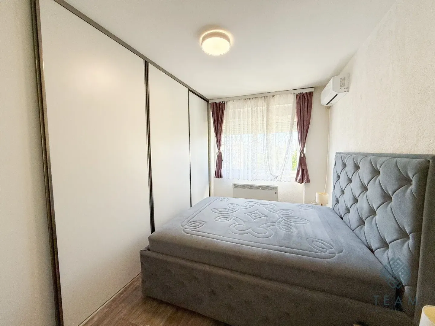 Furnished bedroom with a double bed and a built-in wardrobe.