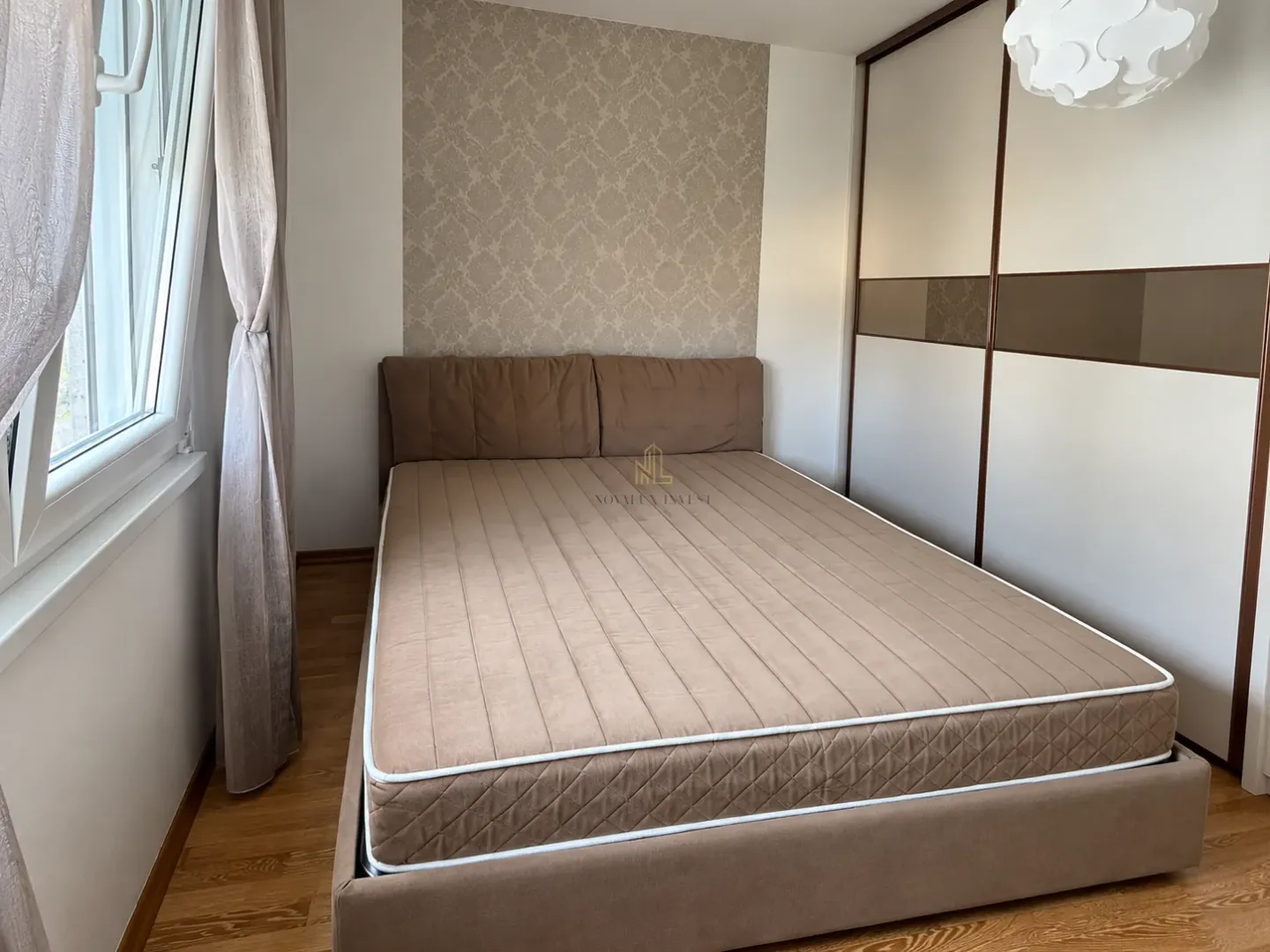 Furnished bedroom with a double bed and a fitted wardrobe.