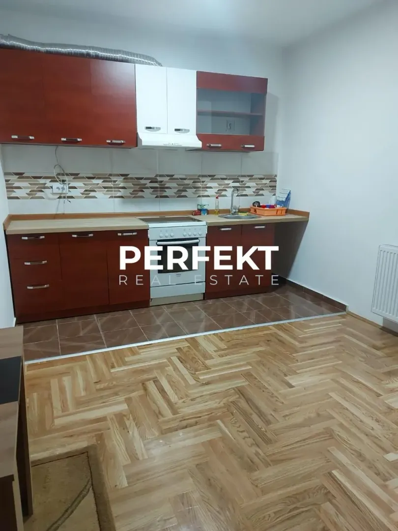 Kitchen with wooden cabinetry and parquet flooring.
