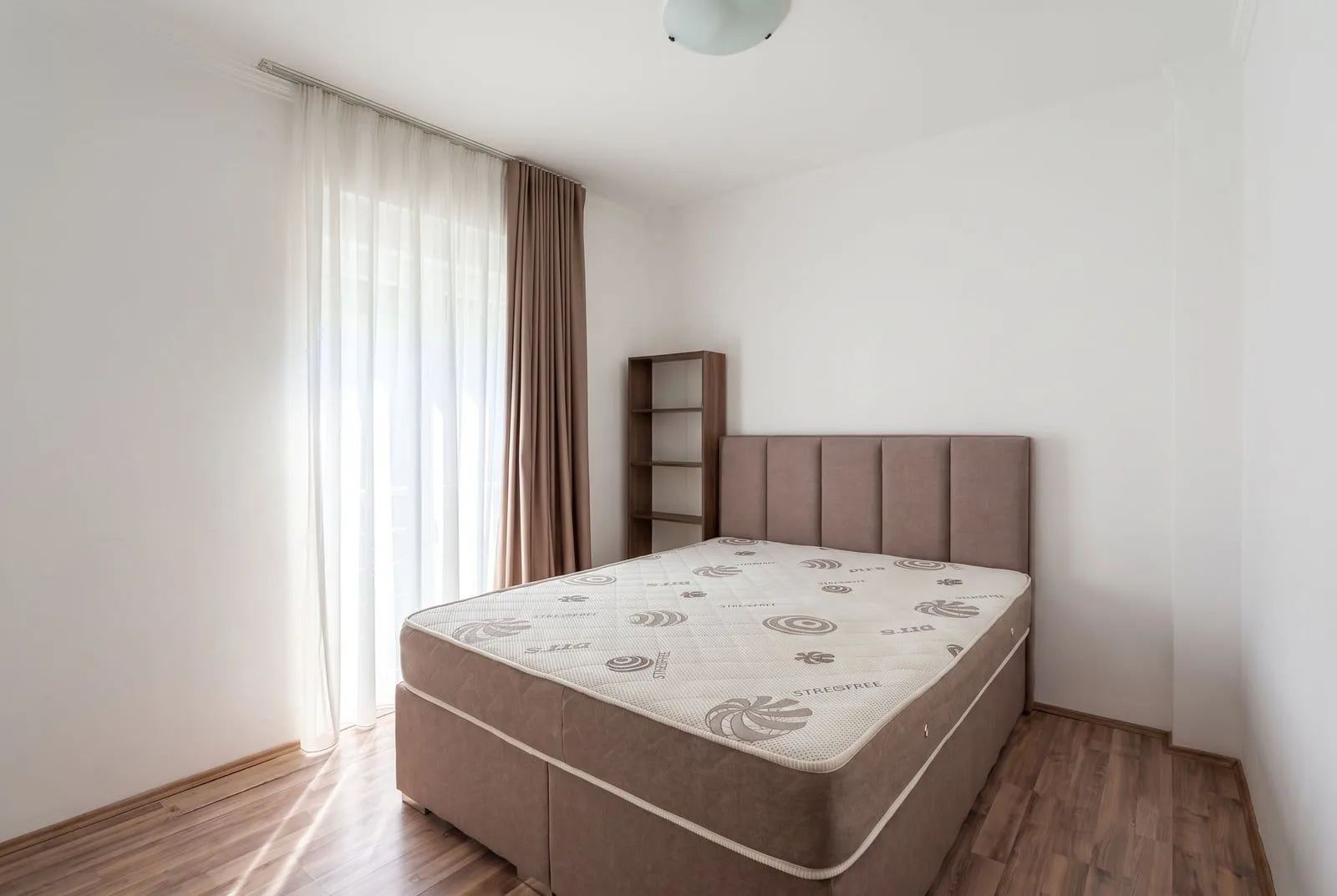 Svijetla spavaća soba sa bračnim krevetom.