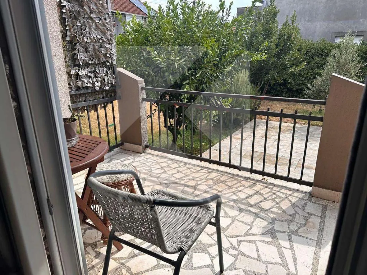 Manja terasa sa garniturom za sjedenje i pogledom na dvorište.