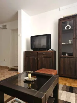 Living room with wooden furniture and a television. - image 3