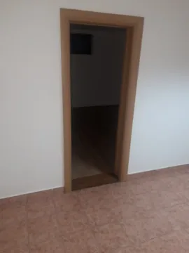 A view through an open wooden door into another room. - image 7