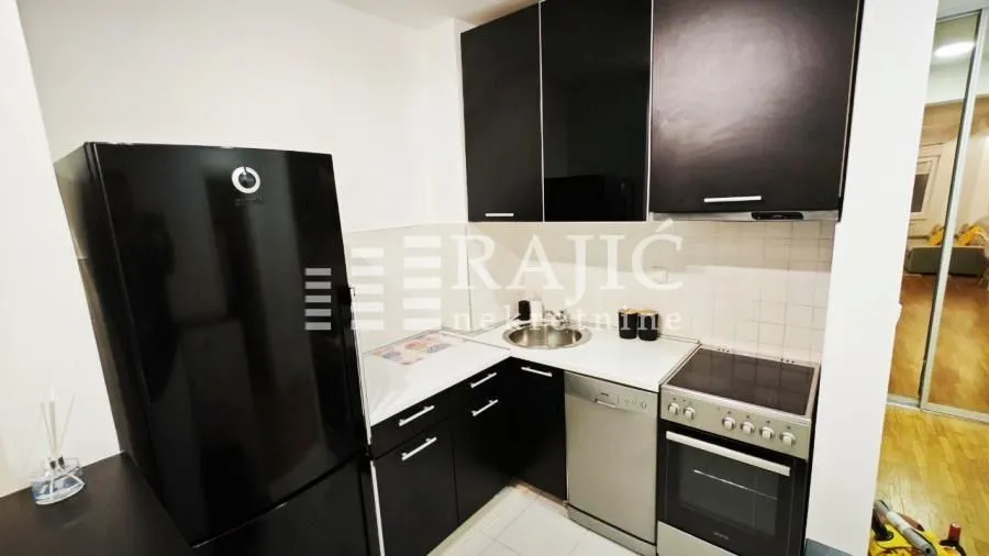 Smaller modern kitchen with black cabinets and a white countertop.