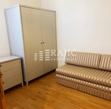 Furnished bedroom with a wardrobe and a sofa. - image 9