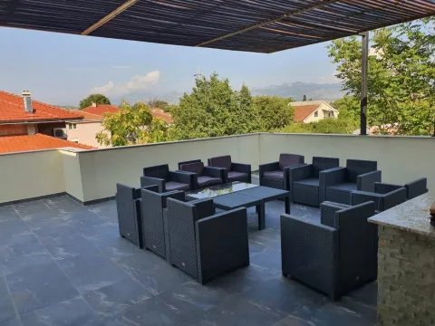 Prostrana natkrivena terasa sa garniturom za sjedenje i pogledom na okolinu. - image 14