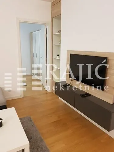 Living room with a TV unit and laminate flooring.