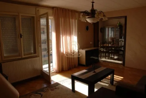 Dnevna soba sa izlazom na terasu i pogledom na susedne zgrade. - image 2