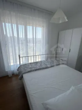 Svjetla spavaća soba sa bračnim krevetom, bijelim garderoberom i velikim prozorom. - image 5
