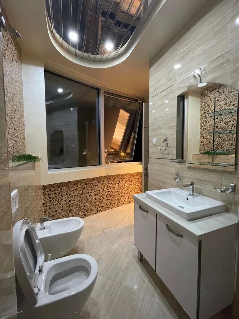 Moderne kupatilo sa umivaonikom, WC šoljom, bideom i velikim prozorom.