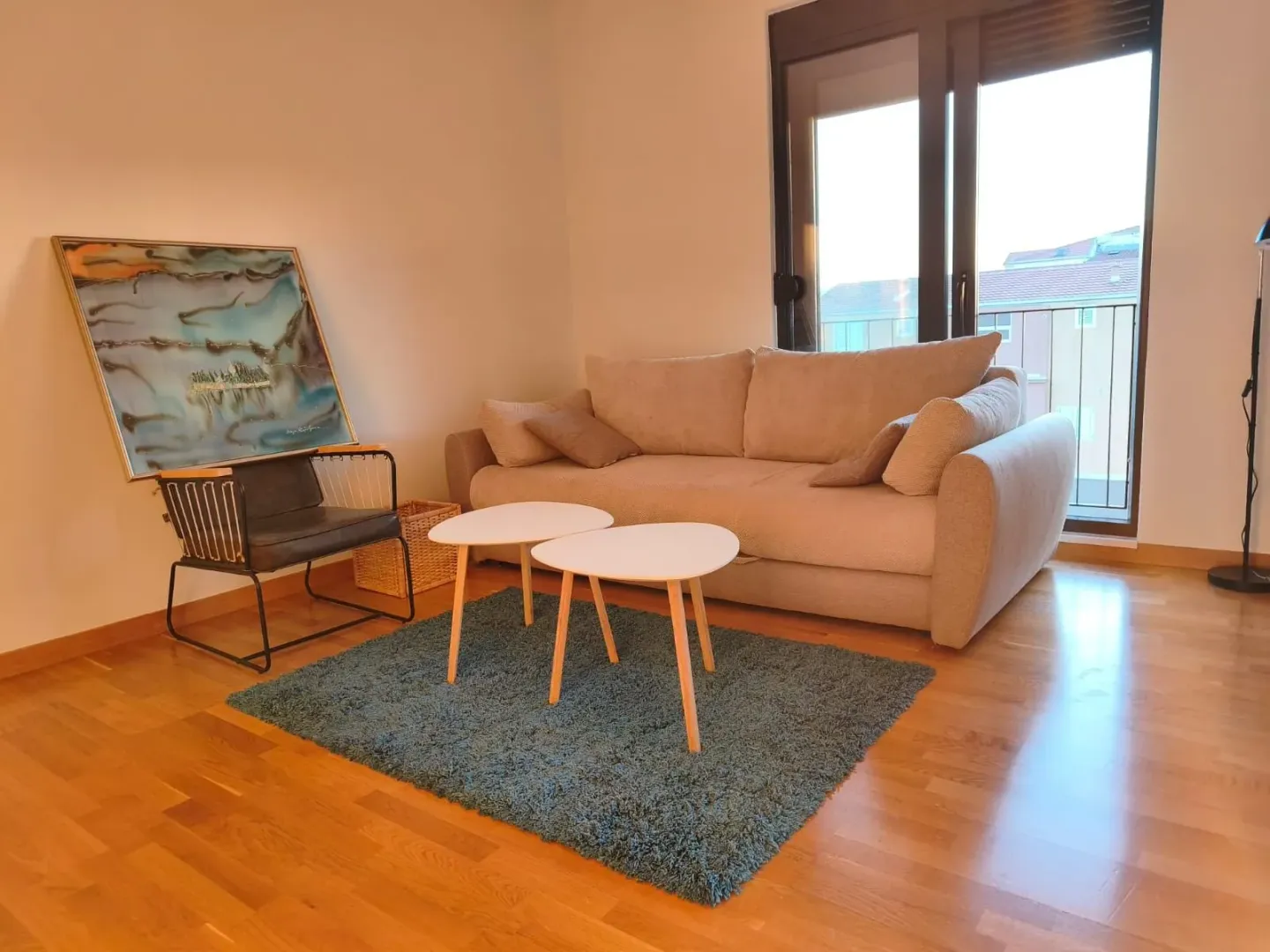 Living room with a beige sofa, coffee table, and a painting on the wall.