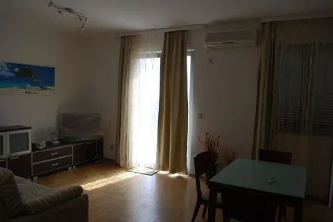 Living room with a sofa, TV cabinet, and dining table. - image 12