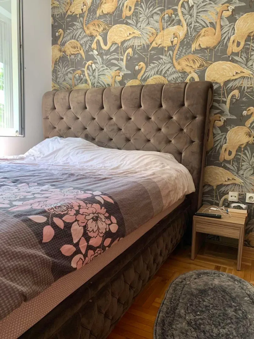 Bedroom with a double bed and flamingo-patterned wallpaper.
