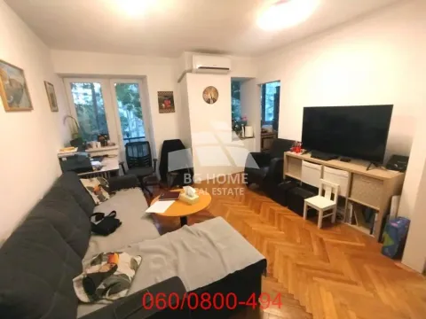 Nameštena dnevna soba sa garniturom, televizorom i parketom na podu. - image 4