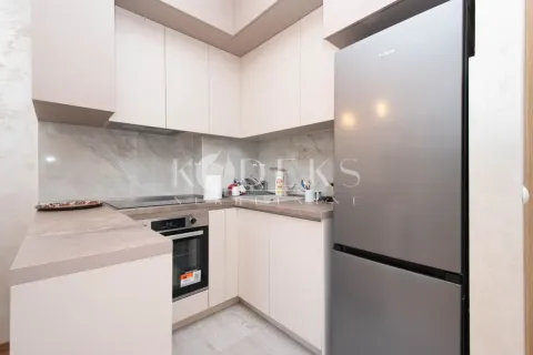 Compact kitchen with light cabinets and built-in appliances. - image 4
