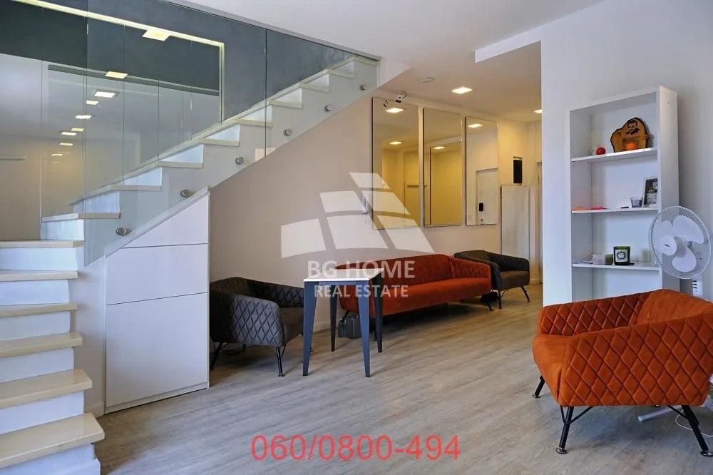 Living room with a sofa, armchairs and stairs.