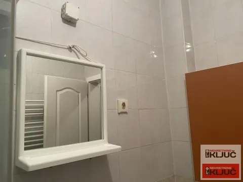 Pogled na ogledalo u kupatilu obloženom pločicama. - image 9